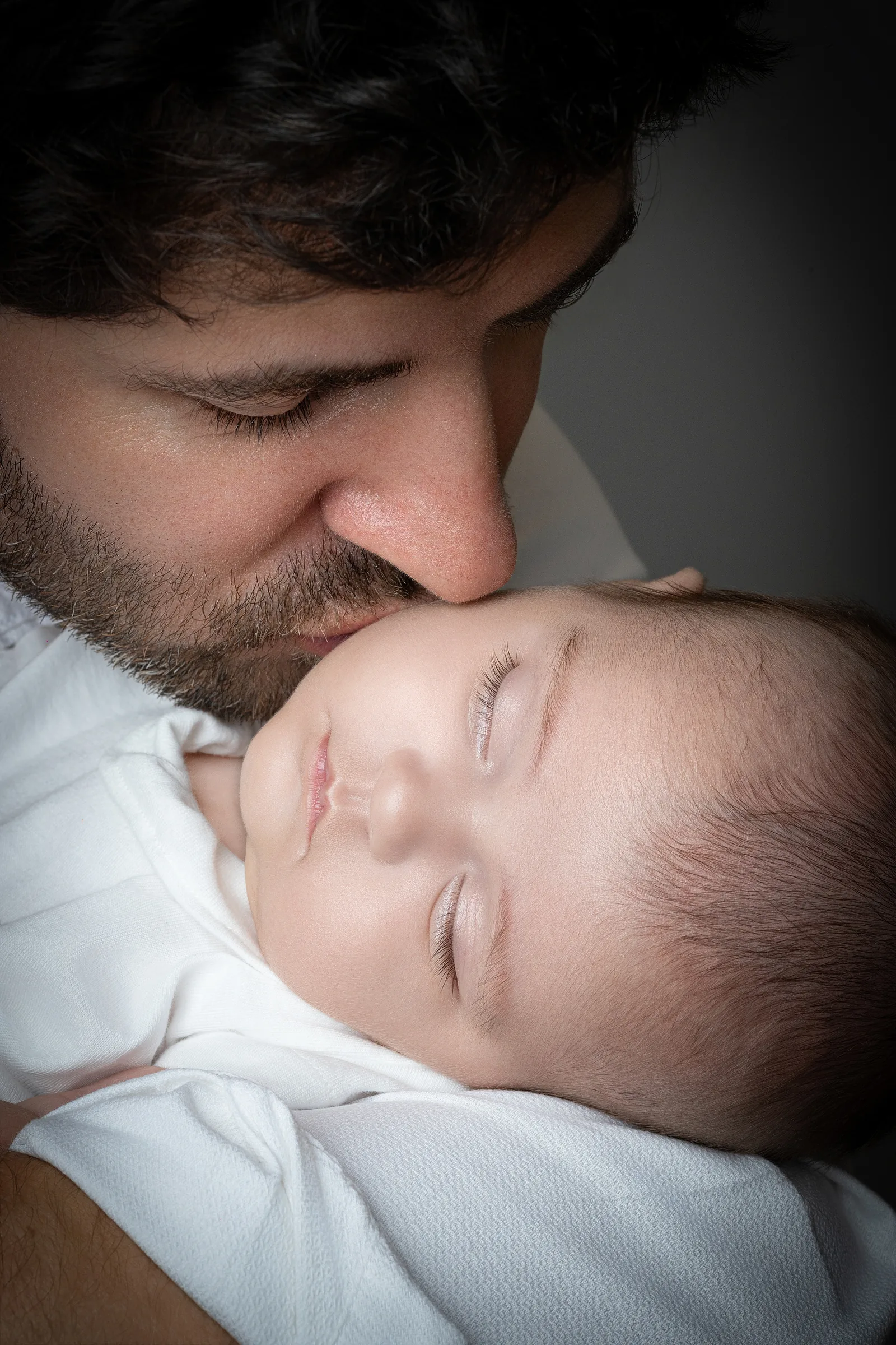 Papa qui embrasse son bébé, séance famille et naissance à Montesson